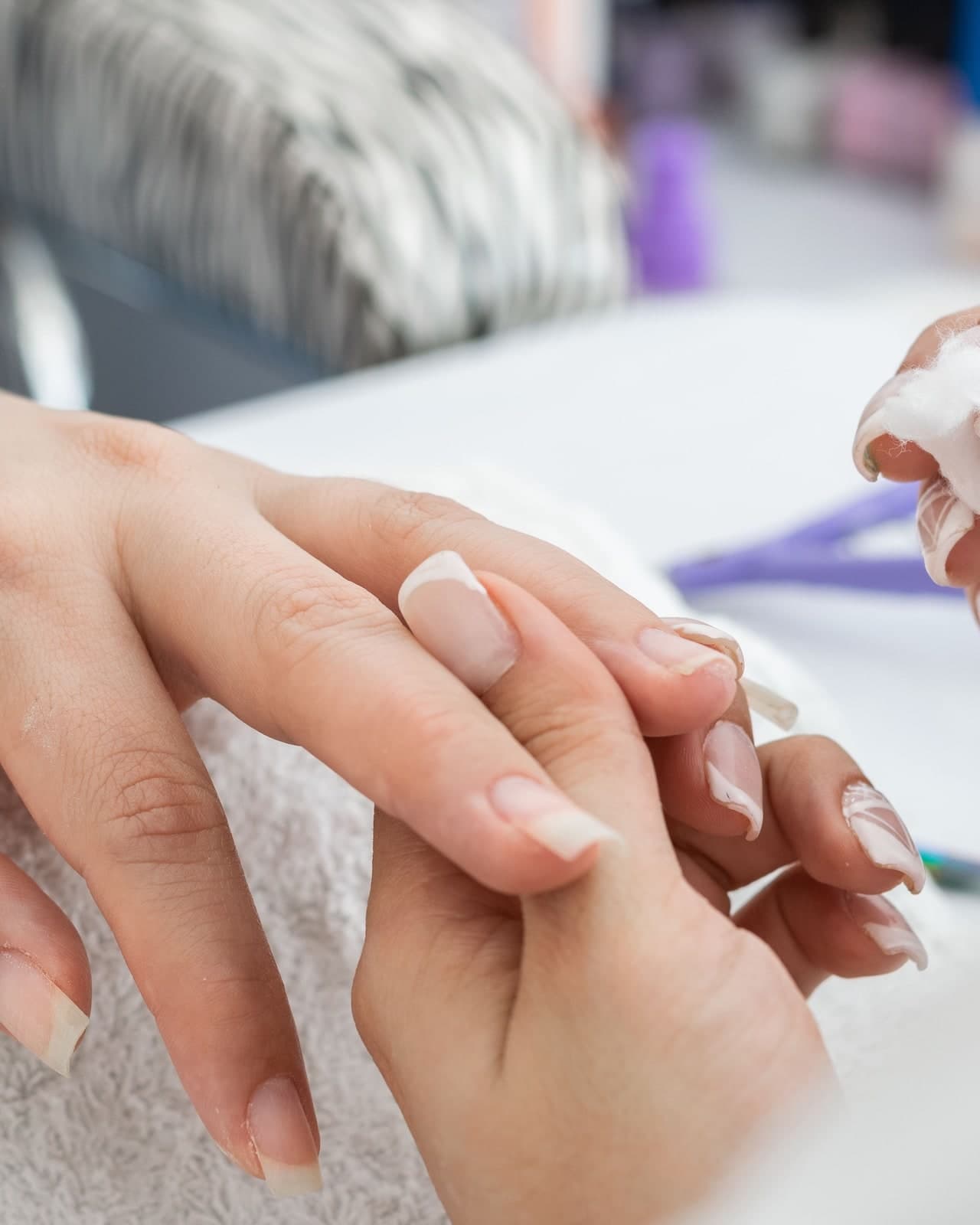 Close-up of a manicure in progress, a technician shaping a client’s nails.