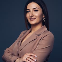 Ilona S., smiling to camera with her arms folded.